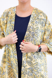 Kimono Brasil na cor amarelo, com estampa Damasco, detalhe da estampa e da abertura frontal.
