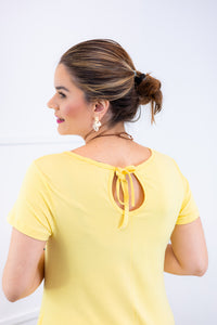 Macacão Origem na cor amarelo, detalhe da amarração nas costas.